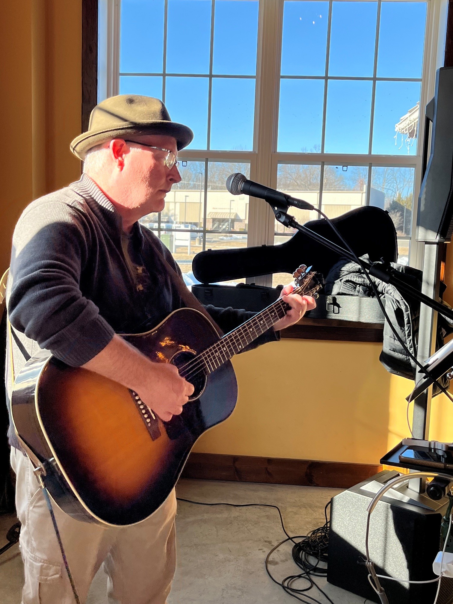 Steve performing with hat by the window