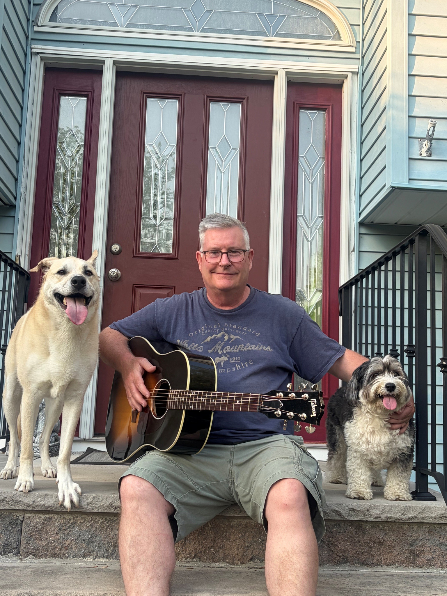 Steve Coombs playing guitar on the front porch with Mable and Molly